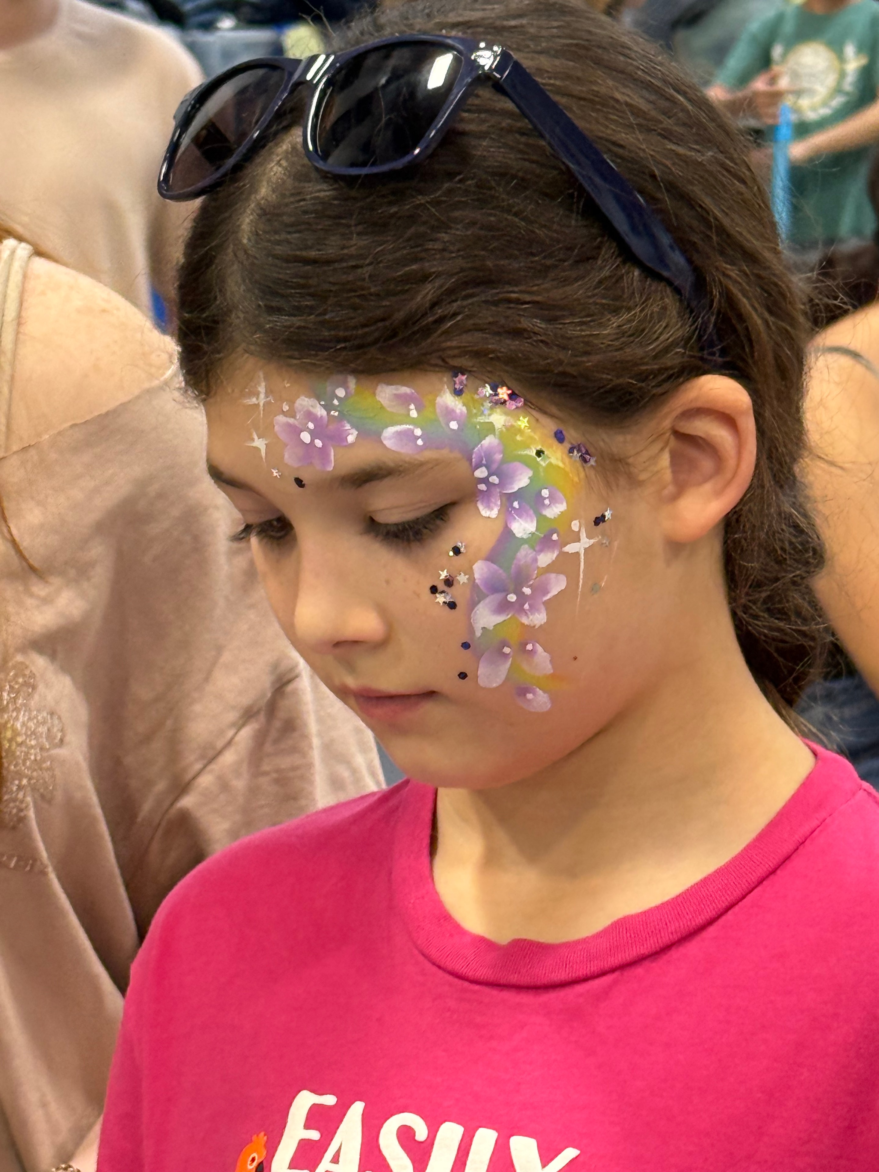 Child with purple floral face paint at the Back to School Health Fair