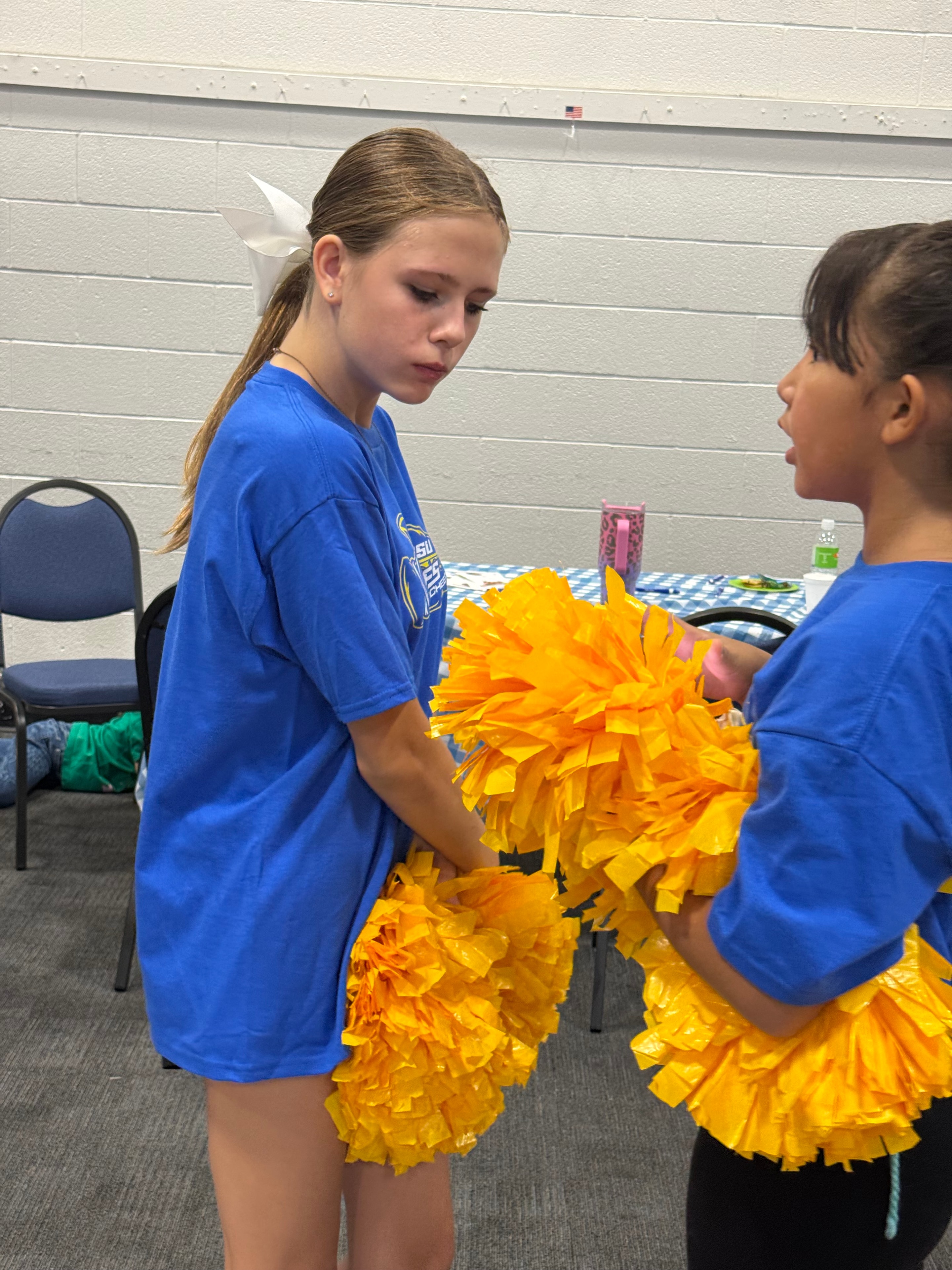 Young cheerleaders with pom-poms at the event
