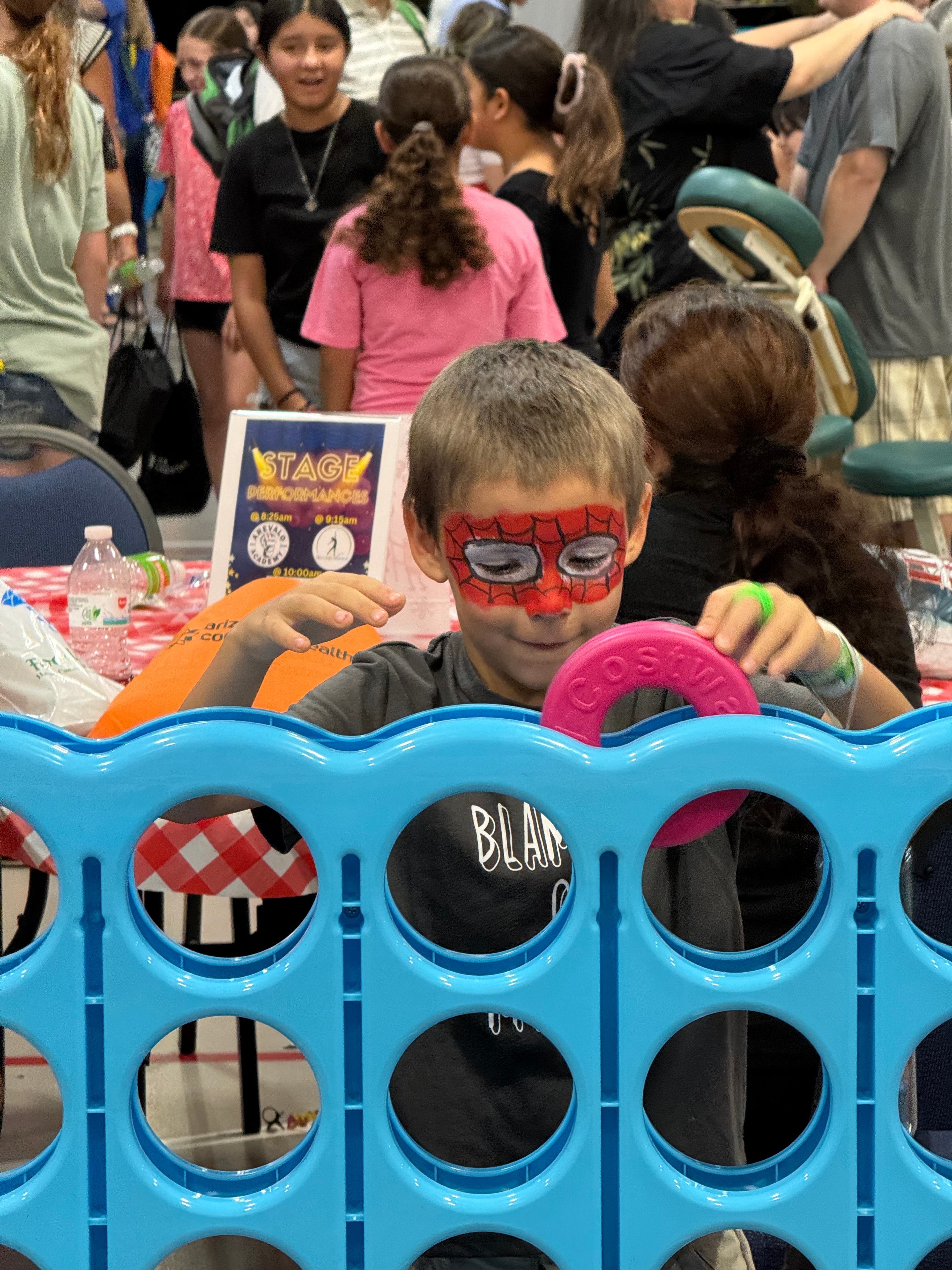 Child with Spider-Man face paint playing Connect Four